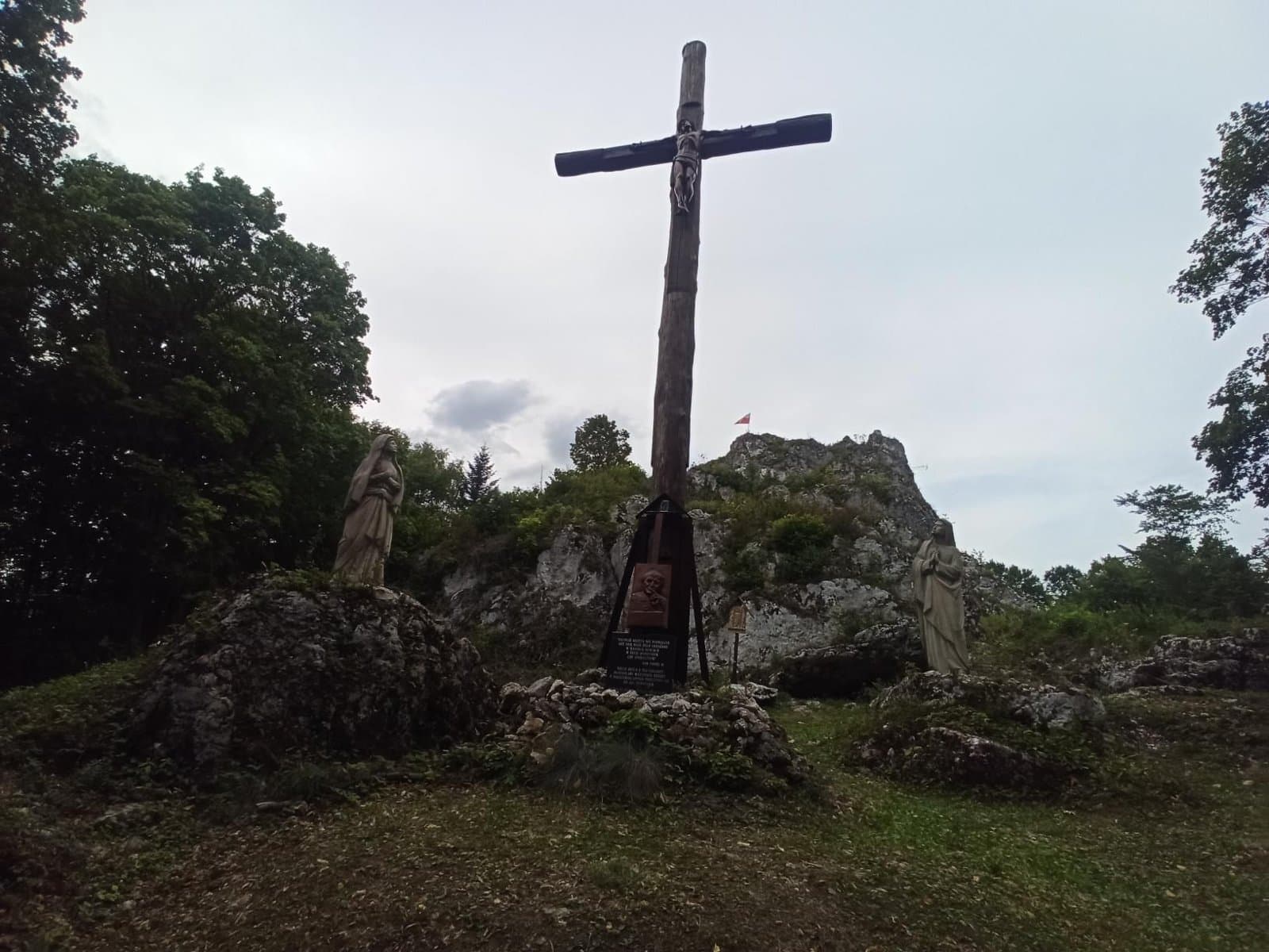 Krzyż na wapiennym wzniesieniu pod zachmurzonym niebem