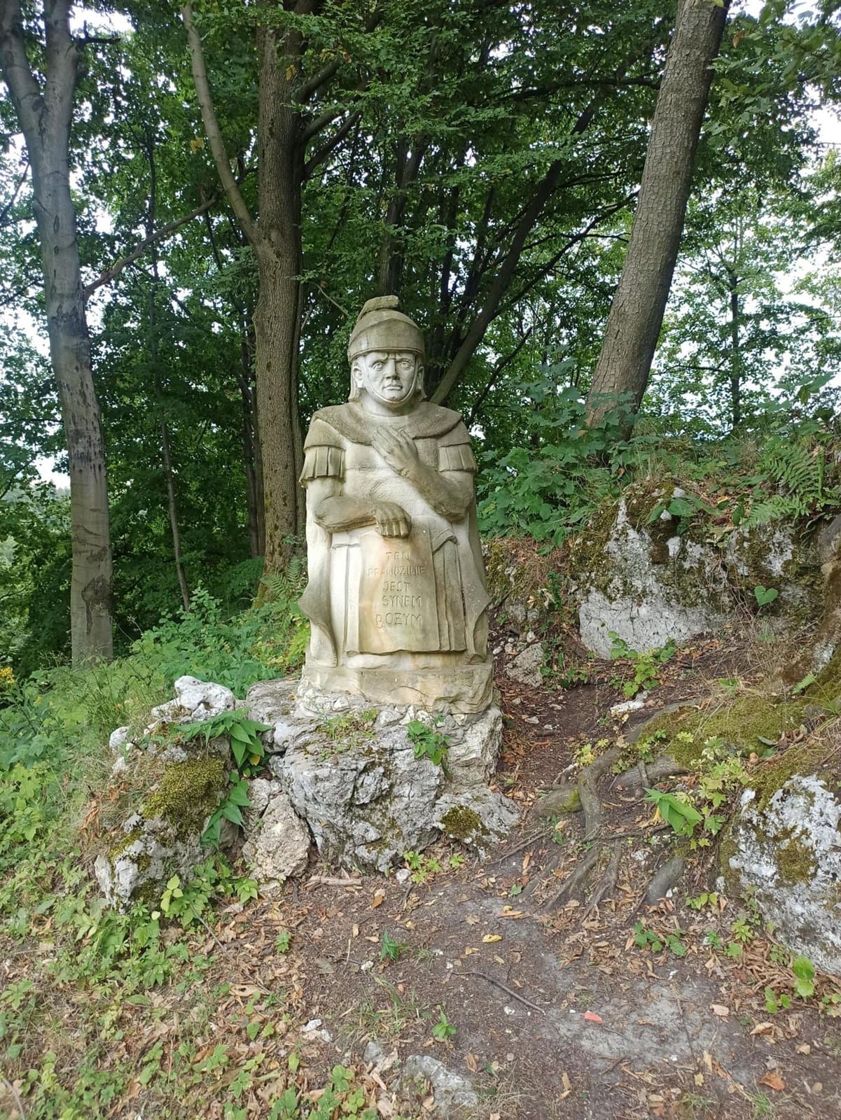 Kamienna figura wśród drzew i wapiennych skał
